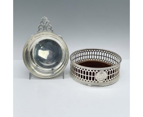 Exquisite, reticulated silver-sided coaster featuring an emblem badge and a turned walnut base. Also, a reticulated decorativ