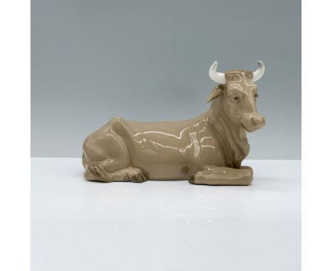 A figurine of a brown calf with gentle horns, seated peacefully on all fours. Nao by Lladro backstamp. This item has its orig