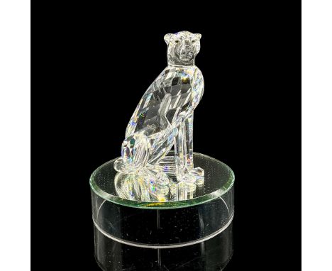 Clear faceted crystal figure of a seated cheetah with amber colored eyes. Retired. Swarovski mark. Item number 7610NR000001. 