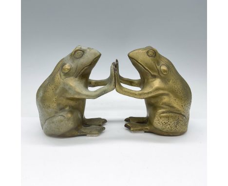 Two charming brass frog-shaped bookends featuring seated frogs holding up books. Both crafted from cast brass and filled with