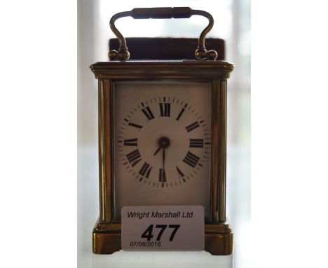 A brass cased miniature carriage clock with brown leather case.