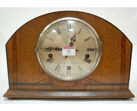 An Art Deco oak cased mantel clock, having silvered dial with Roman numerals