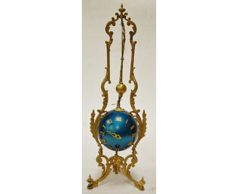 A mystery clock in the form of a blue globe with Roman numerals suspended within a gilt metal frame (a/f)