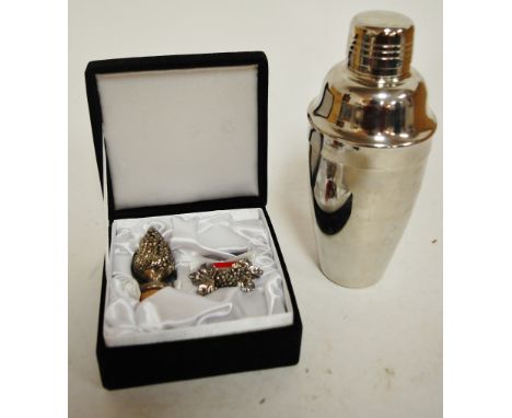 A modern white metal mounted bottle stopper and matching napkin ring together with an Art Deco style cocktail shaker