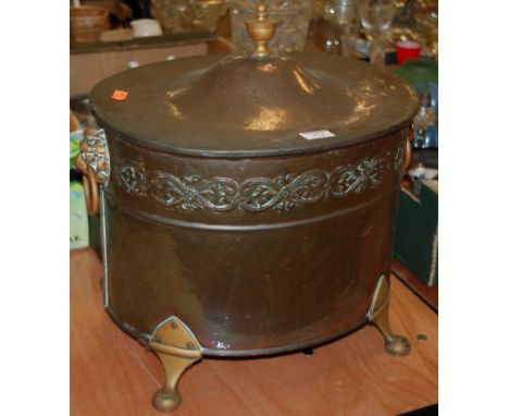 A 19th century copper fuel depot, having removable lid with galvanized liner, flanked by lion mask ring handles, on brass sup
