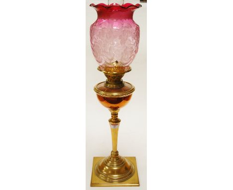 A Victorian oil lamp, having etched cranberry tinted glass shade above a copper reservoir, on a brass pedestal base Condition