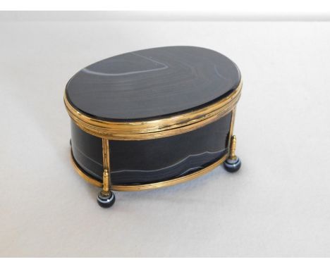 Onyx and gilt mounted oval 4-panel lidded trinket box with onyx ball feet -size 11cm x 8½cm x height 6½cm (4¼"x3¼"x2½")