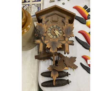 A VINTAGE CUCKOO CLOCK WITH PENDULUM AND WEIGHTS