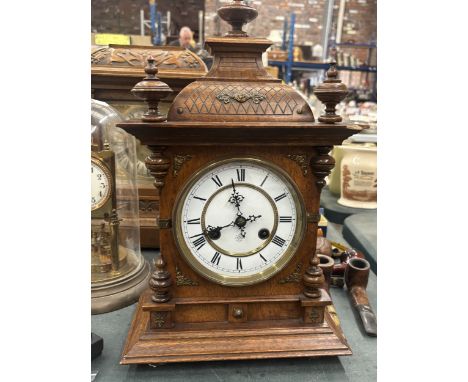 A JUNGHANS WALNUT CHIMING MANTEL CLOCK WITH KEY AND PENDULUM LIKELY FROM THE LATE 19TH EARLY 20TH CENTURY
