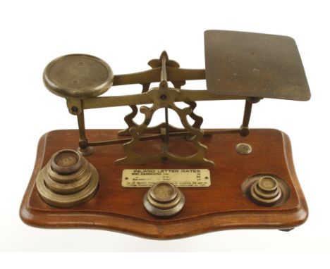 A 19c brass postal scale with list of charges eg 1 oz. 1d etc c/w various brass weights G+