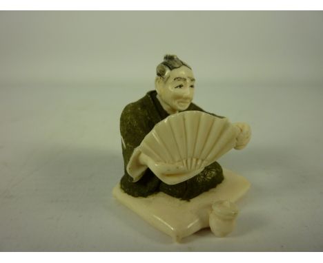 Early 20th century Japanese carved ivory netsuke in the form of a Shogun seated on a cushion signed 3.5cm