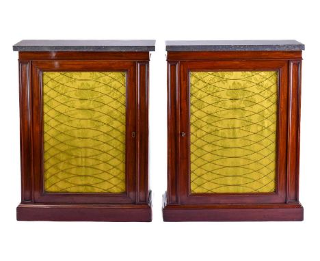 A pair of Regency style mahogany marble topped pier cabinets, partly 19th century, each with a single door fitted a recessed 
