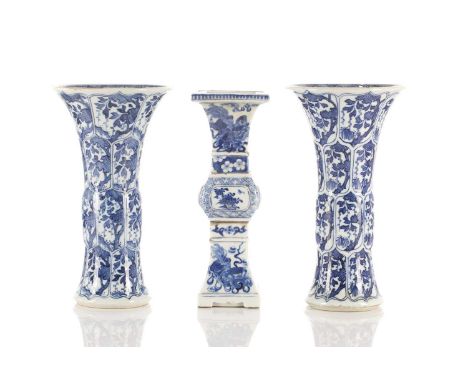 A close pair of Chinese blue &amp; white Gu vases, Qing, Kangxi period, painted with foliage in shaped panels with swollen ce