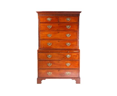 A George III mahogany chest on chest, with carved frieze and brass furniture, two short over six long drawers, on bracket fee