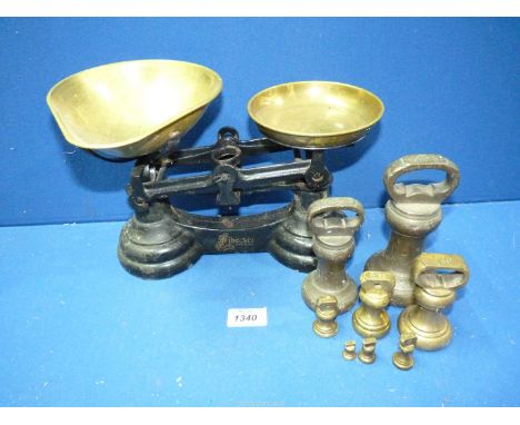 A set of Weighing scales with brass pans and various brass weights including 2lb and 4lb weights.