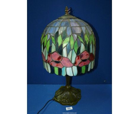 A Tiffany style table lamp , the shade having red poppy design on a base with daffodil decoration, 23'' tall.