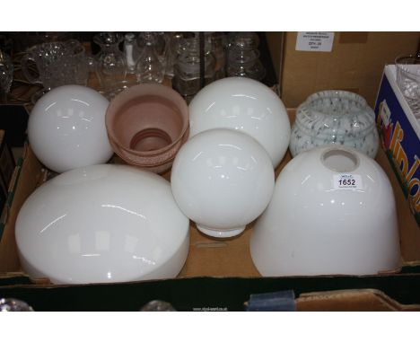 A box of globe shaped opaque Light shades plus two pink smaller ones.