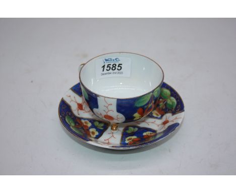 A dainty porcelain tri footed cabinet teacup with saucer, decorated with four panels having blossoms on a blue ground with he