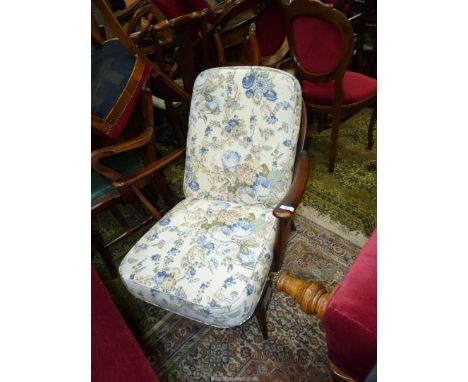 A stickback Ercol type open armed Fireside Armchair having cream ground blue floral decorated cushions.