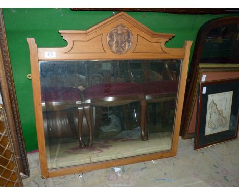 A lightwood framed bevel edged mantle mirror with carved panel in an arched top to the frame, 28" wide x 29" high.