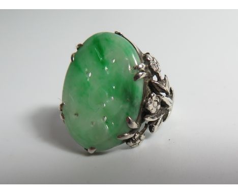 A Carved Jade Ring in a white metal mount, jade 20 x 9 mm 