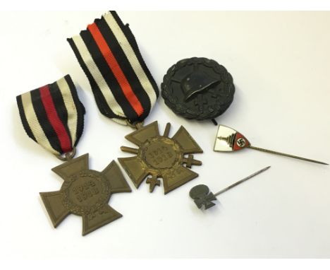 Five various German medals and badges including two stick pins.