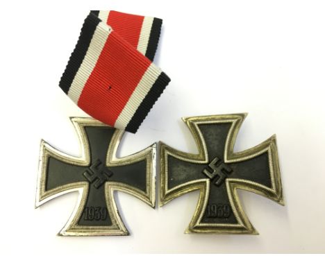 A pair of WWII German Nazi Iron Cross First and Second Class medals with ribbons.