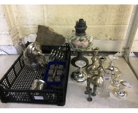 A collection of various silver plated items including candlesticks and serviette rings together with an oil lamp base.