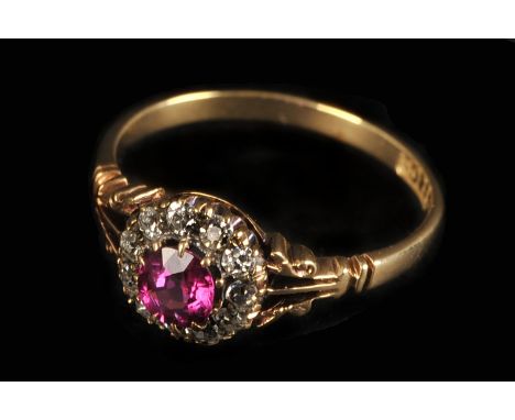An Edwardian 18ct gold ruby and diamond ring, the circular cluster of old cuts centred with a red stone and having triple spl