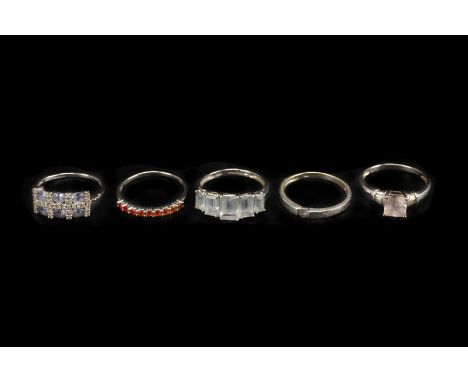 Five modern white 9ct gold and gem set dress rings, including a five stone set with light blue stones, a seven stone with sma