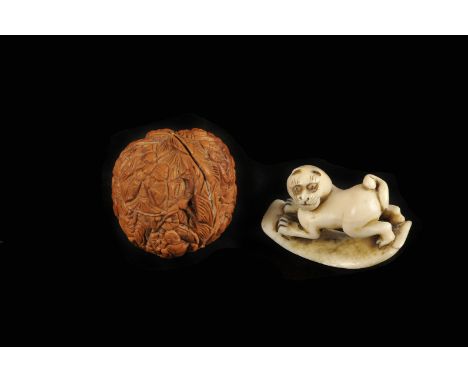 An Edo period ivory netsuke, as a cat on a curved board, signed to the base 4.5cm W, together with a carved walnut decorated 