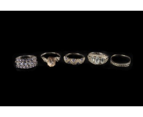 Five modern white 9ct gold and gem set dress rings, including a pink solitaire with pierced shoulders, a cluster with pierced