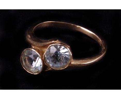 A vintage 9ct gold and aqua marine ring, the crossover mount set with two round cut light blue stones