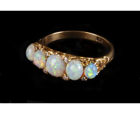 An Edwardian period five stone opal ring, the 18ct gold mount set with graduating oval polished opals and also set with small