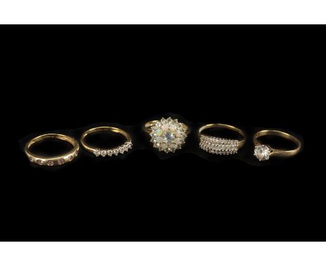 Five modern gold and gem set dress rings, including a 14ct gold and CZ solitaire, a cluster set with light blue stones and op