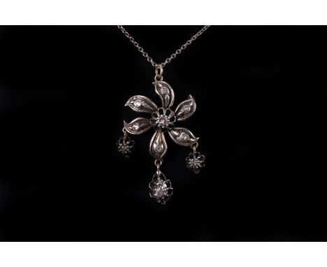 A vintage Indian silver and diamond pendant, the flower shaped mount set with rose cuts and three drop, supported on a white 