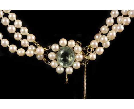 A three strand cultured pearl necklace, the knotted strings with removable central string, having a yellow metal clasp set wi