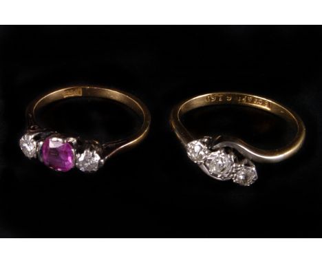Two vintage 18ct gold and gem set three stone rings, one being a crossover, the other with a synthetic ruby and two brilliant