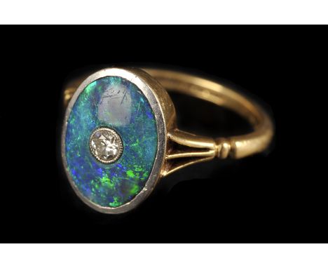 A vintage opal and diamond dress ring, the oval platinum tablet set with a green and blue opal centred with an old cut, on go