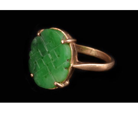 A vintage Chinese hardstone child’s ring, the oval jade or jadeite panel with engraved and pierced design set in a yellow met