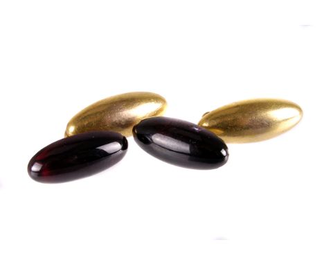 A pair of vintage garnet mounted cufflinks, each with an elongated oval red polished stone on yellow metal panel and chain li