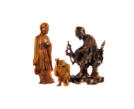 An early 20th century Chinese root carving of the fasting Buddha, seated with a scroll in hand, plus two later carvings, one 