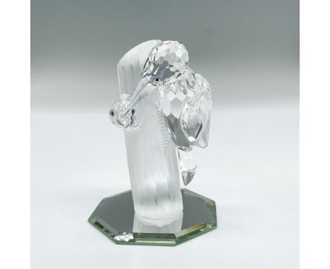 Sparkling clear faceted crystal figure of mother woodpecker and the face of a chick peeking out. Frosted crystal tree trunk. 