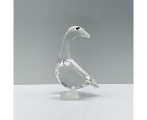 A clear crystal goose with its head turned 180 degrees accented with black crystal eyes and a frosted crystal beak and feet. 