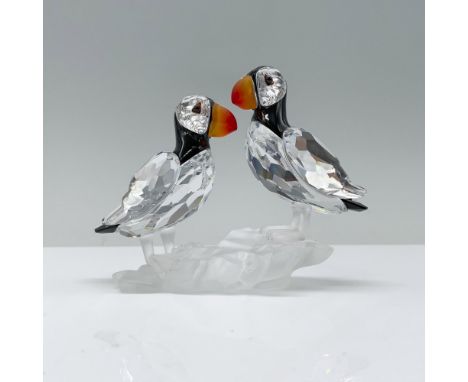 A charming pair of clear crystal puffins, with sleek black crystal heads and backs and vibrant red and yellow gradient beaks,
