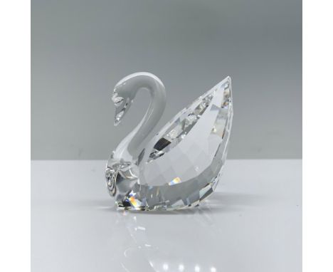 A mesmerizing clear crystal swan, artfully crafted to mirror the company's iconic logo, gracefully poised in a swimming posit