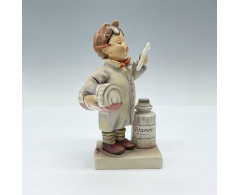 Enchanting figurine of a boy holding a syrup bottle and reading a recipe trying to act like a pharmacist. MI Hummel imprint t