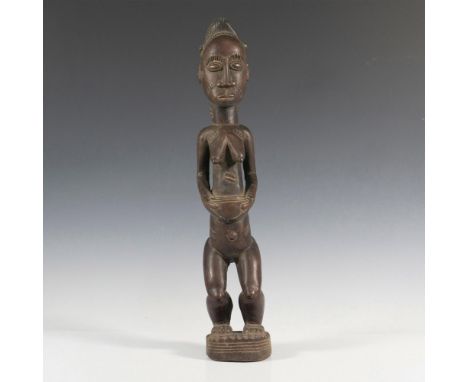 Crafted from rich, dense wood, this vintage hand-carved figurine brings to life a scene of village life, featuring a woman gr