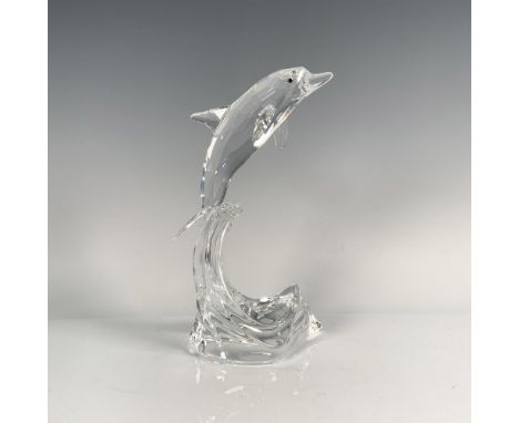 A beautiful clear crystal dolphin, adorned with melon-colored eyes, gracefully rides atop a crystal wave. Swarovski backstamp