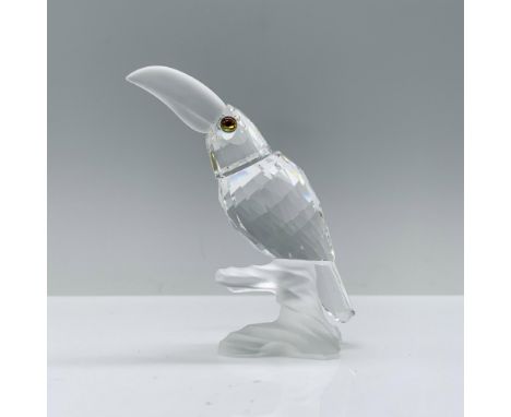 A clear crystal toucan with melon-colored eyes, its head slightly raised, accented with frosted crystal for its beak and the 